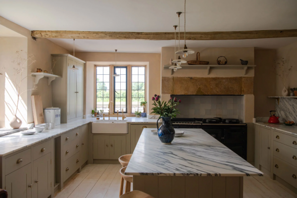 Dapur dengan island besar berbahan marmer dan kursi bergaya vintage